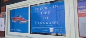 Check in Koh Lipe to Langkawi A sign in a window displaying Check in Koh Lipe to Langkawi poster